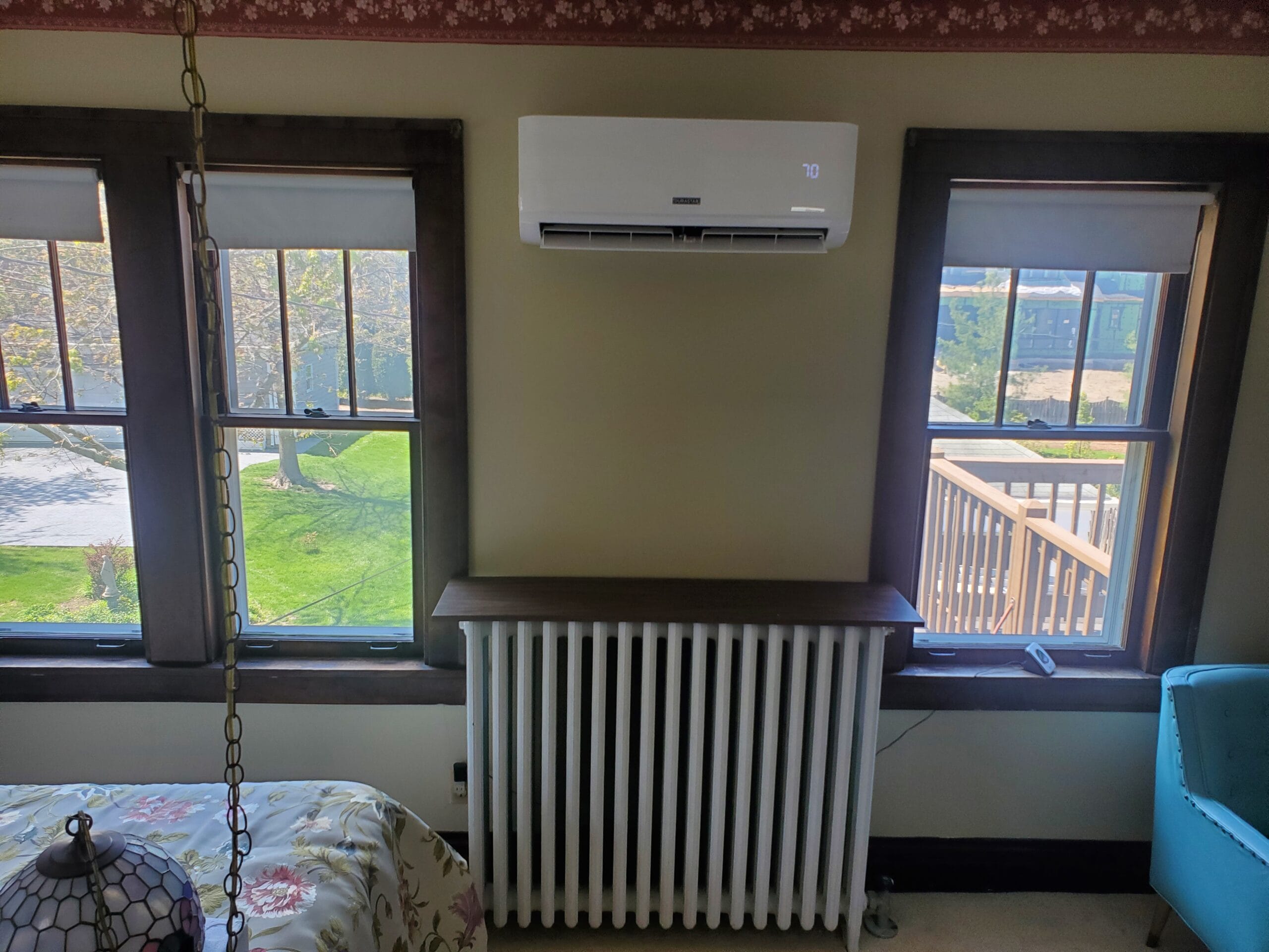 A mini-split head unit mounted above a hot water radiator.